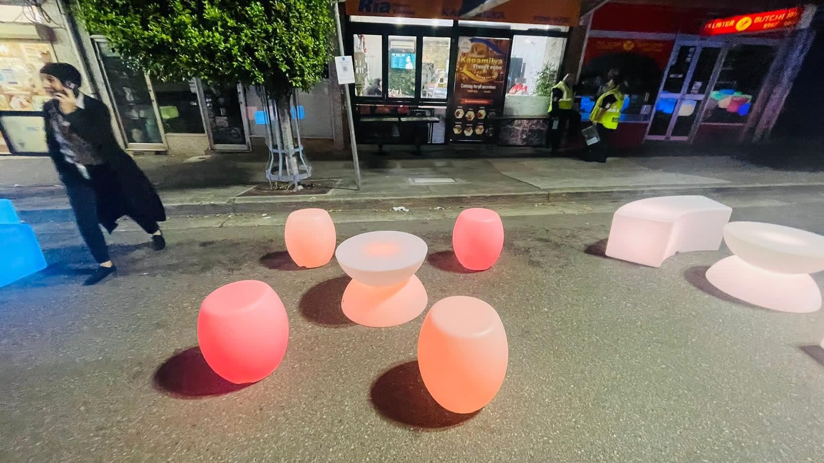 A vibrant arrangement of glow stools on a bustling street.