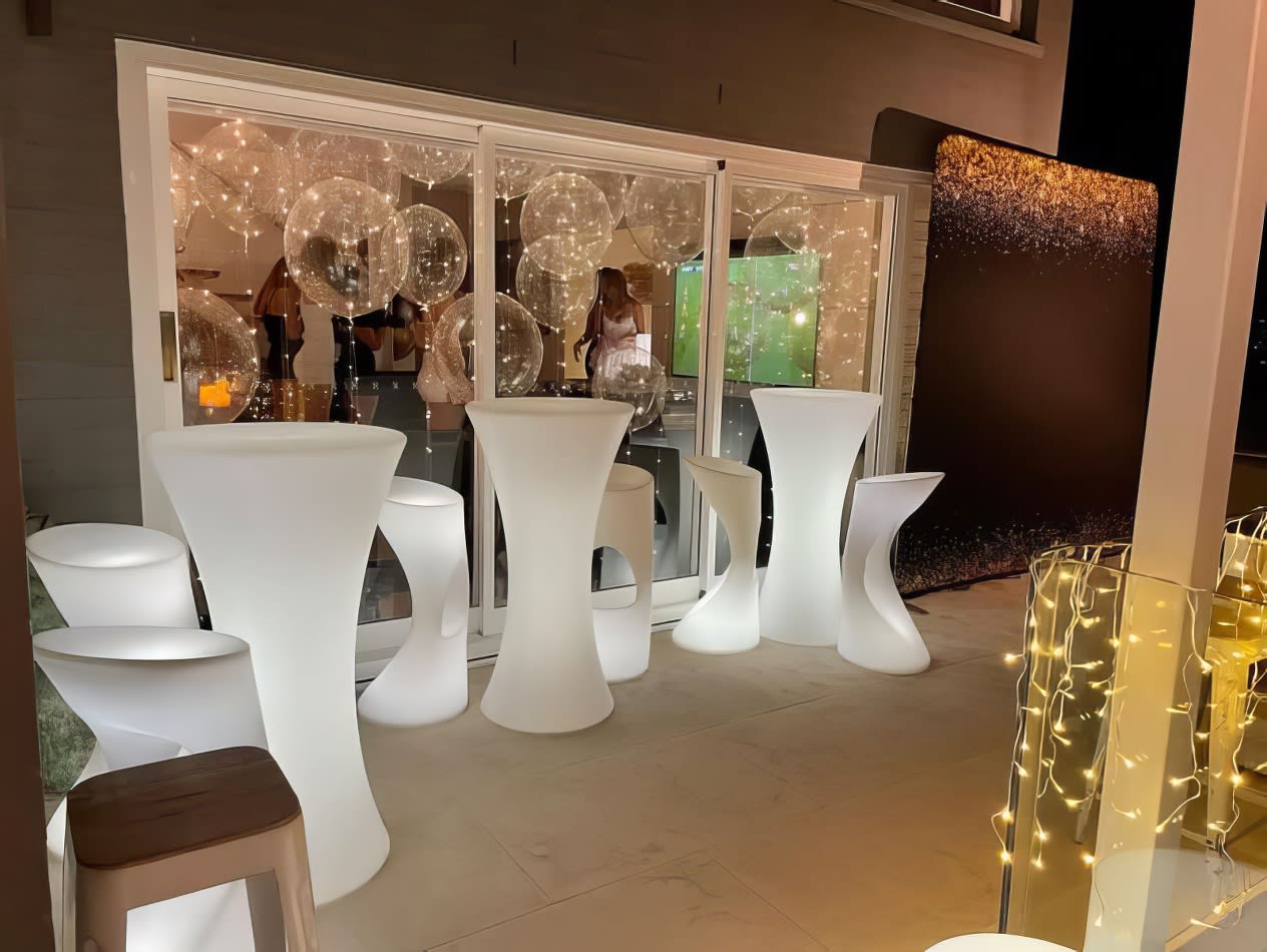 A group of white stools and a Glow Cocktail Bar table hire with lights.