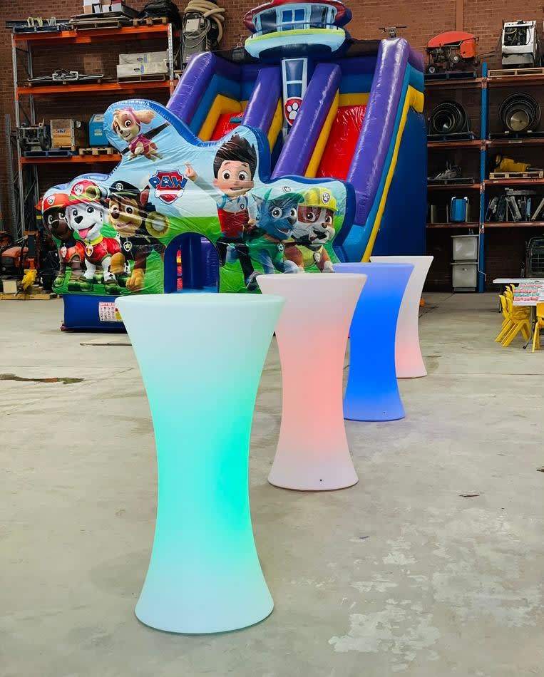 A group of colorful LED bar stools in a warehouse, available for Glow Cocktail Bar Table Hire.