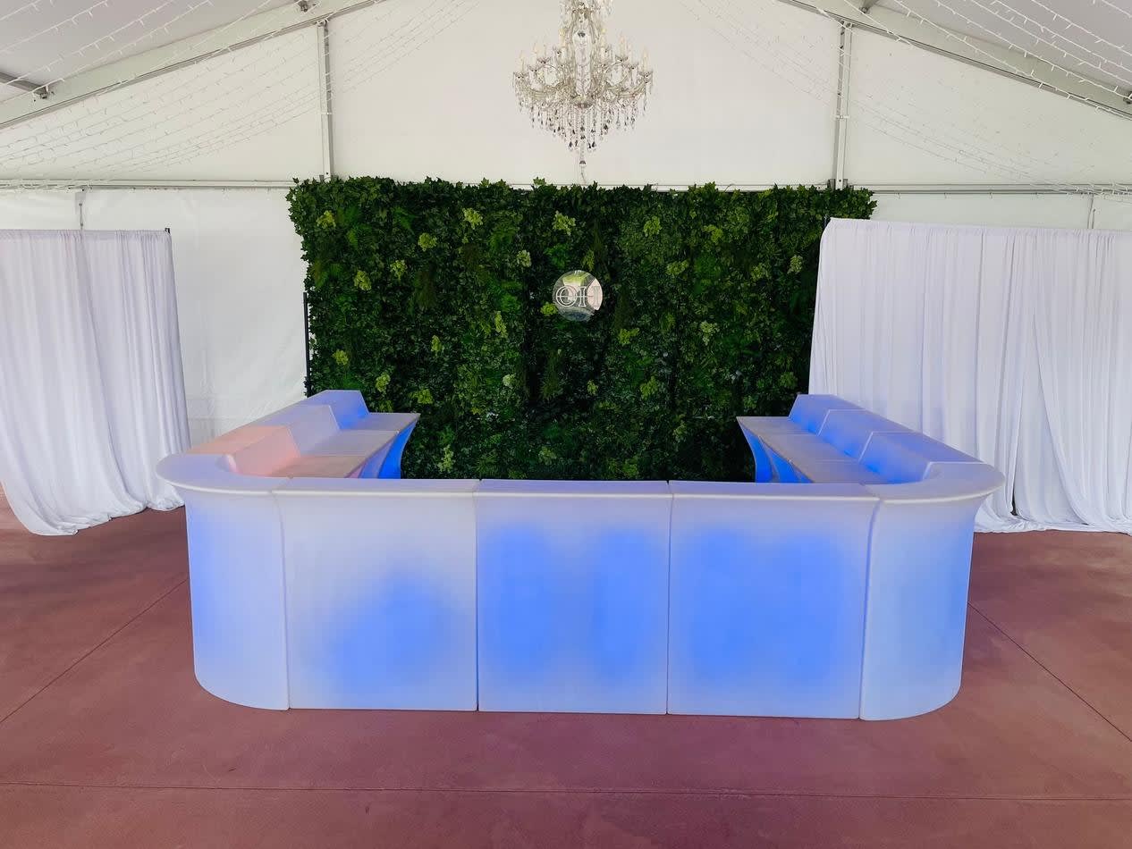 A vibrant Glow Corner Bar set up in a tent with mesmerizing blue lights.