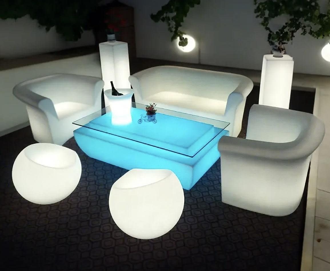 A living room with a white sofa, chairs, and a coffee table available for Glow Couch Hire.