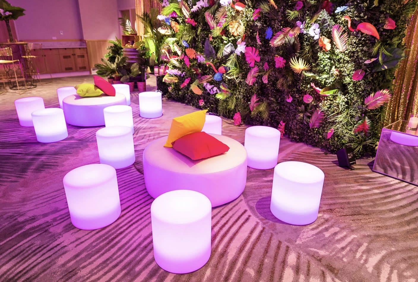 A room filled with colorful stools and plants, perfect for Glow Cylinder Seat Hire.