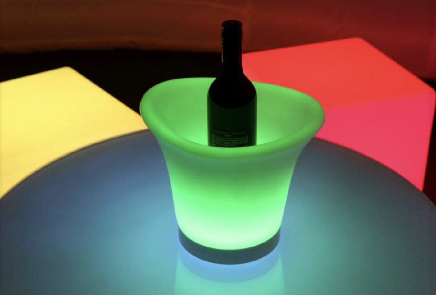 Glowing ice tub hire showcases a bottle of wine nestled in a colorful ice bucket.