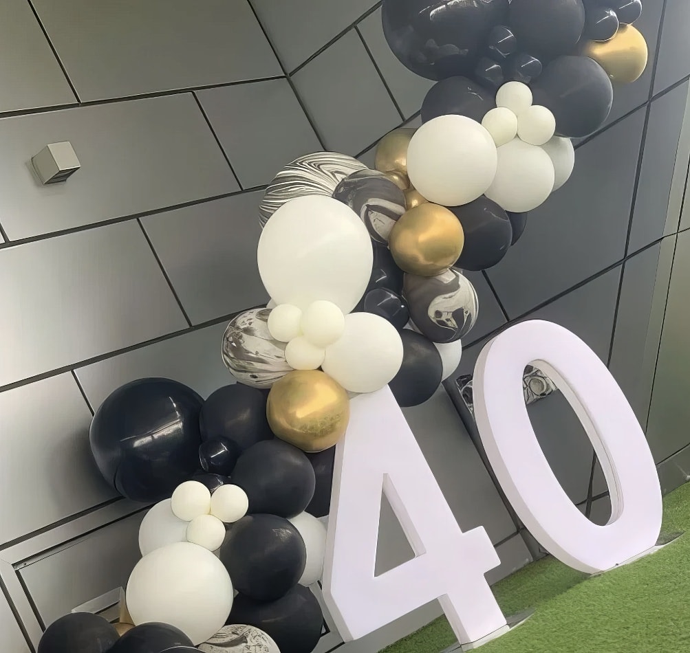 A black and gold balloon arch with a number 40 on it, available for Glow Numbers Hire.