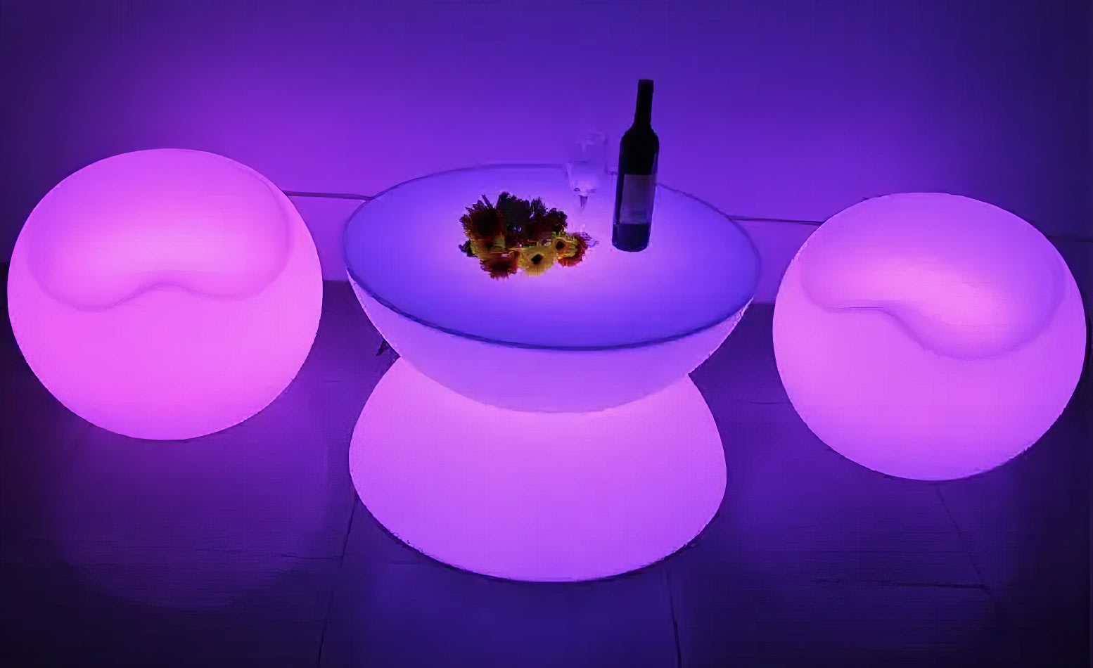 A purple LED table with a bottle of wine.