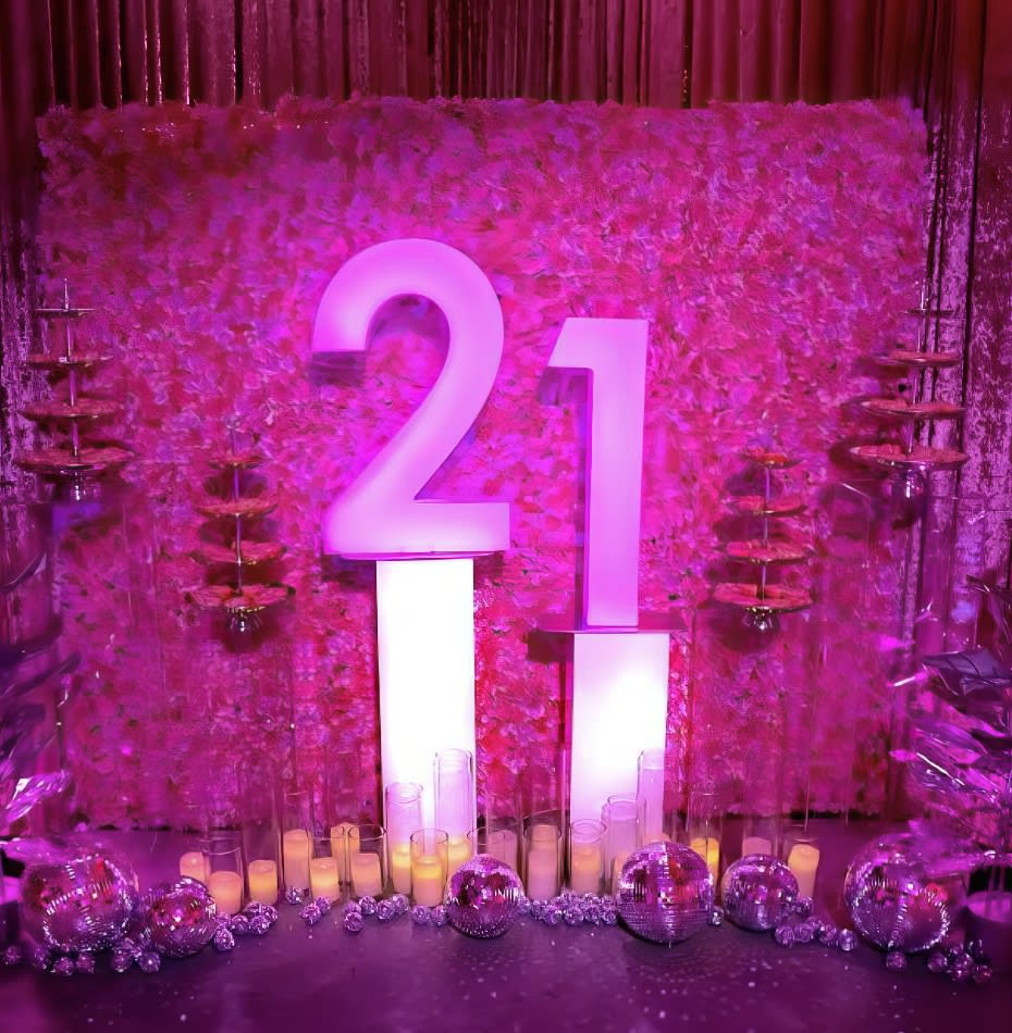 A pink backdrop with the number 21 on it for hire.