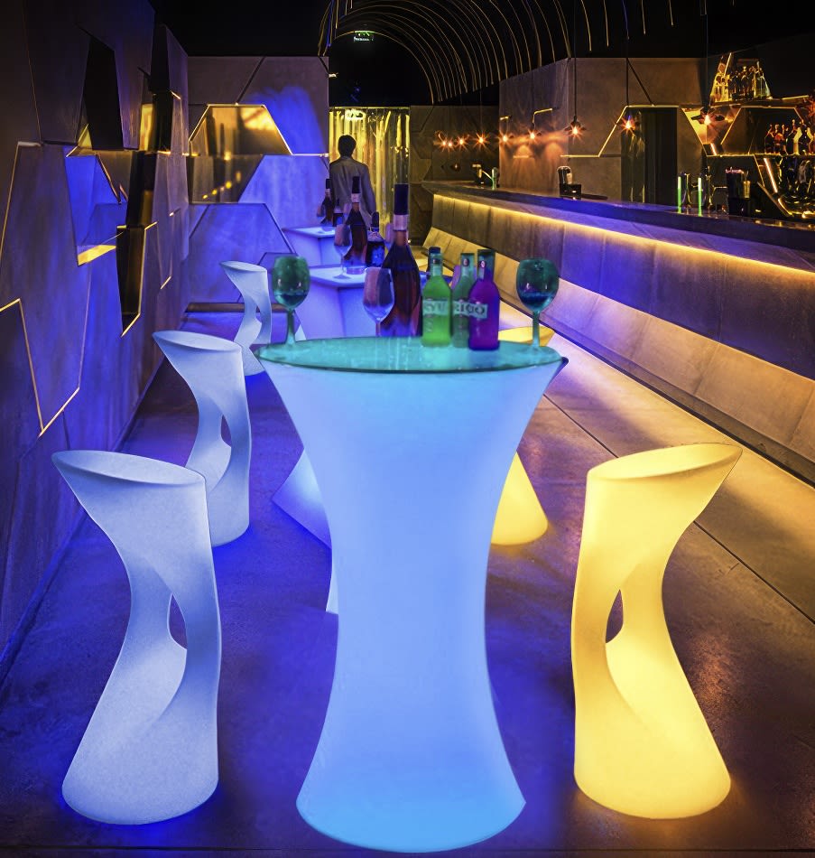 A colorful bar with glow stools and chairs.