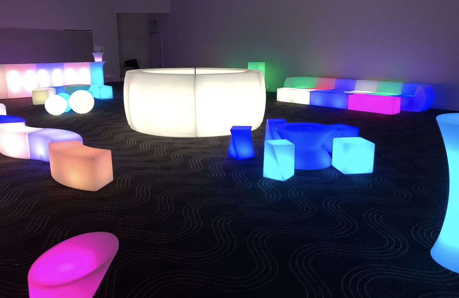 A room full of colorful LED stools and tables available for hire.