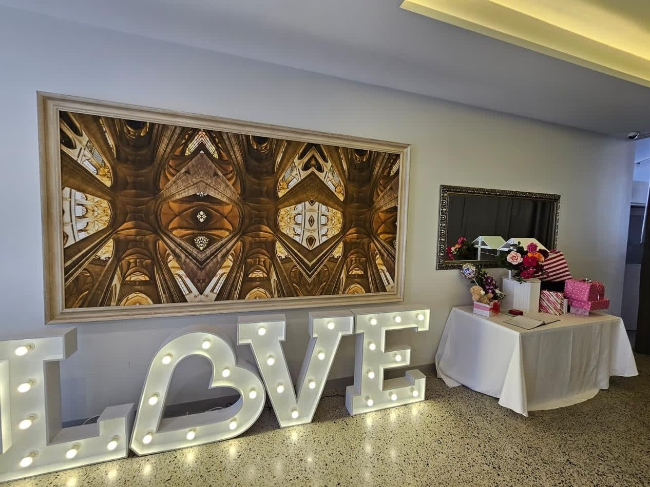 The love sign is illuminated in front of a table.