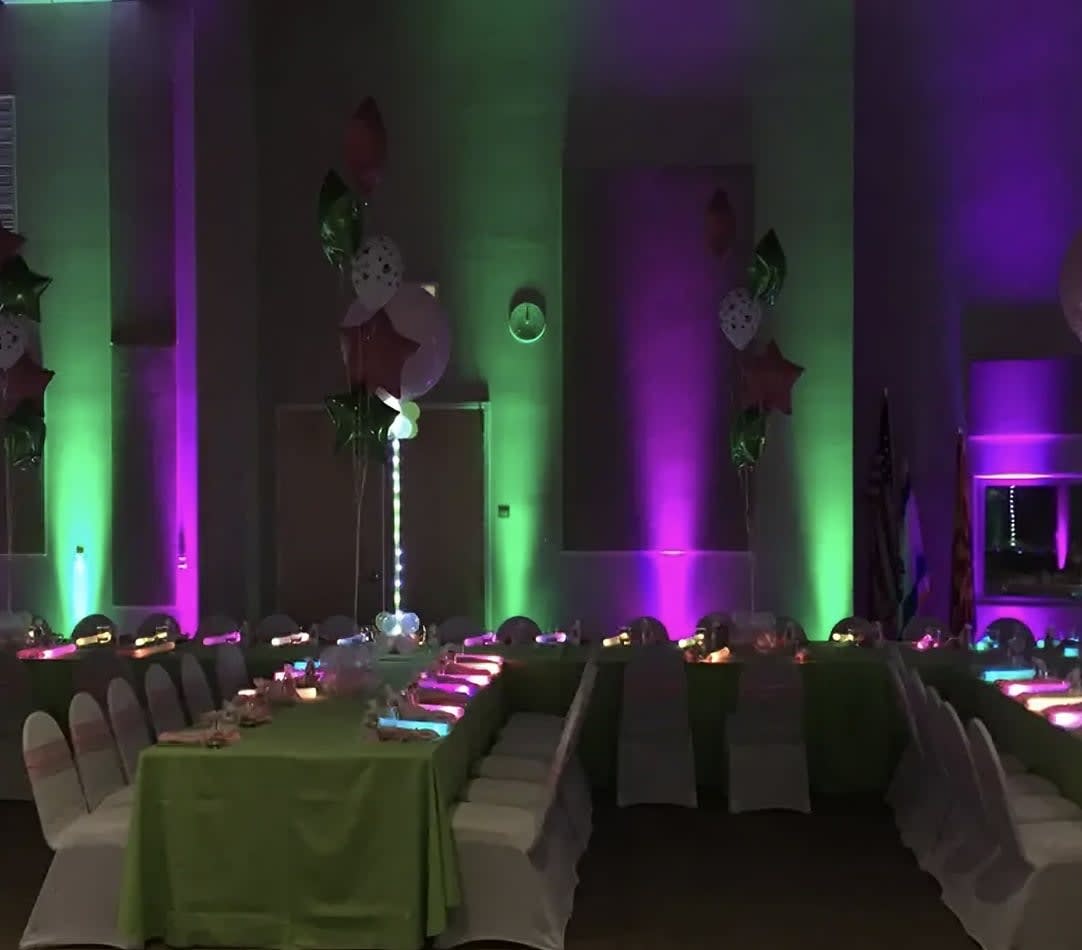 A party room with Par Can light hire, creating a vibrant atmosphere with green and purple lights.