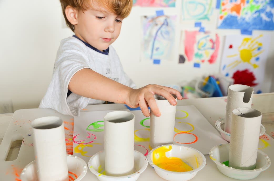 A young boy playing with home-made paints