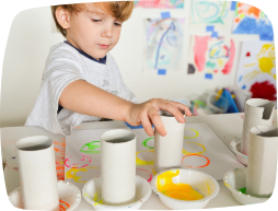 A young boy playing with home-made paints