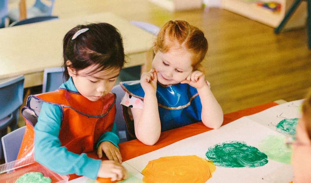 Two young girls at childcare painting together