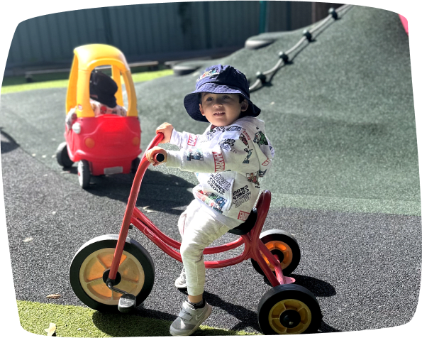 Happy toddler riding a bike at Playbright Marayong