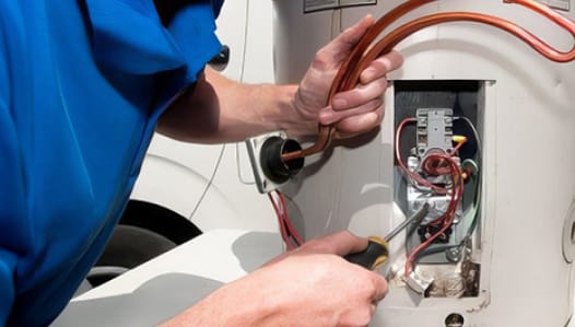 An electrician repairing an electric hot water system