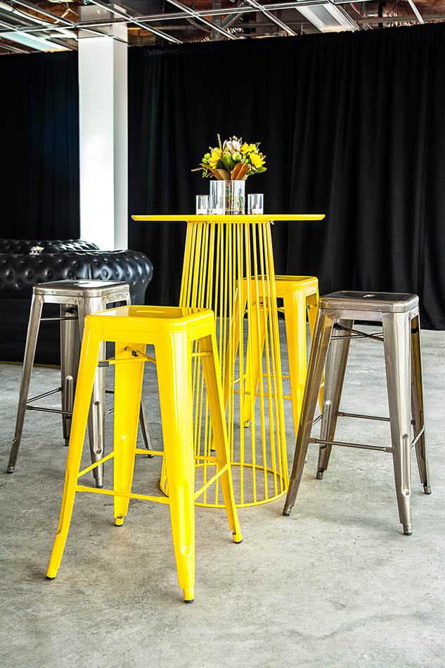 Yellow wire cocktail table with Tolix stools