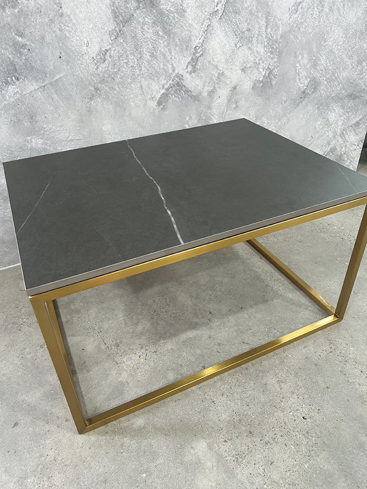 Rectangular Gold Coffee Table Hire next to a marble wall