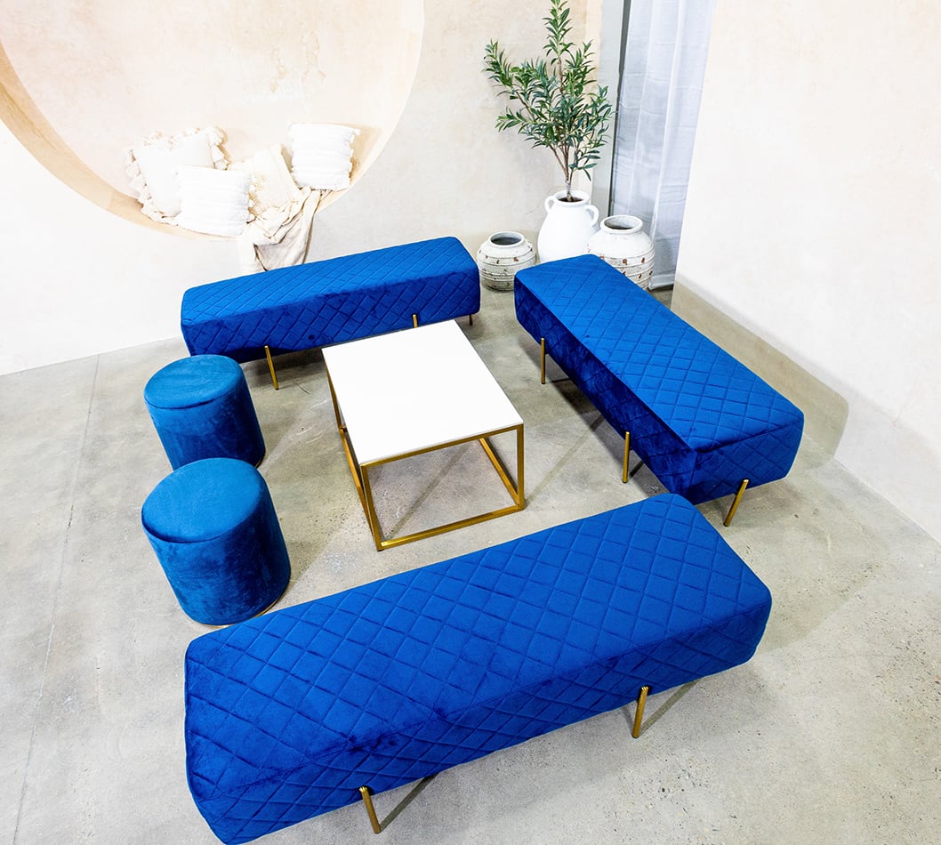 Gold coffee table hired with blue velvet lounge