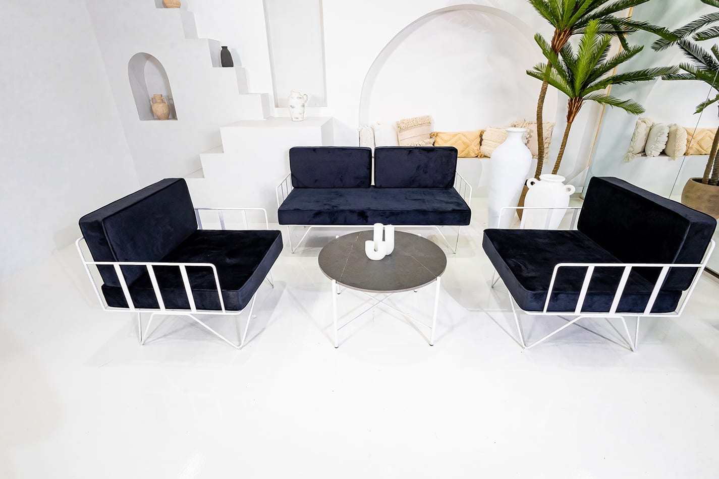 A White cross coffee table next to a blue lounge