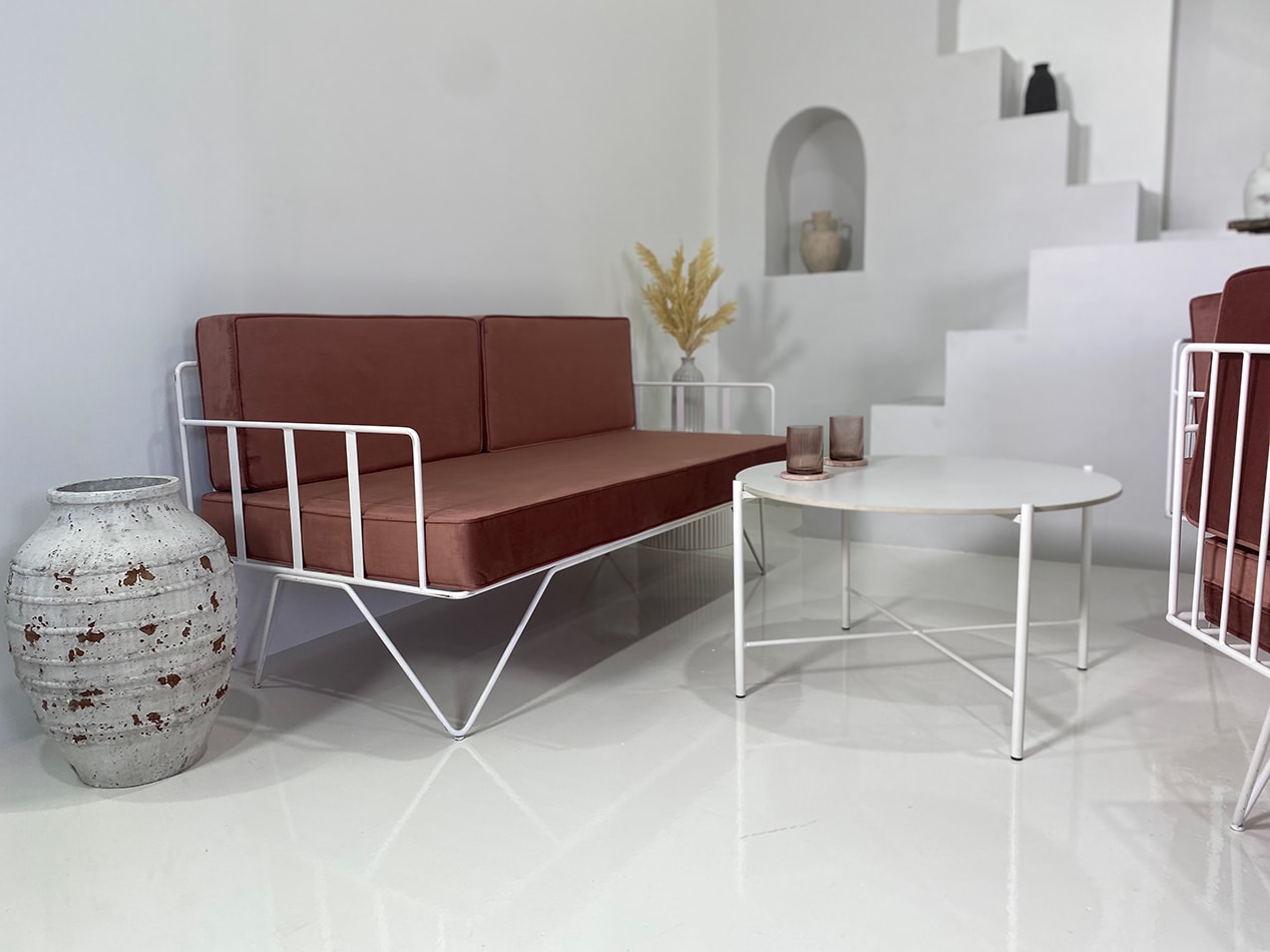 White Cross Coffee Table next to a brown wire lounge