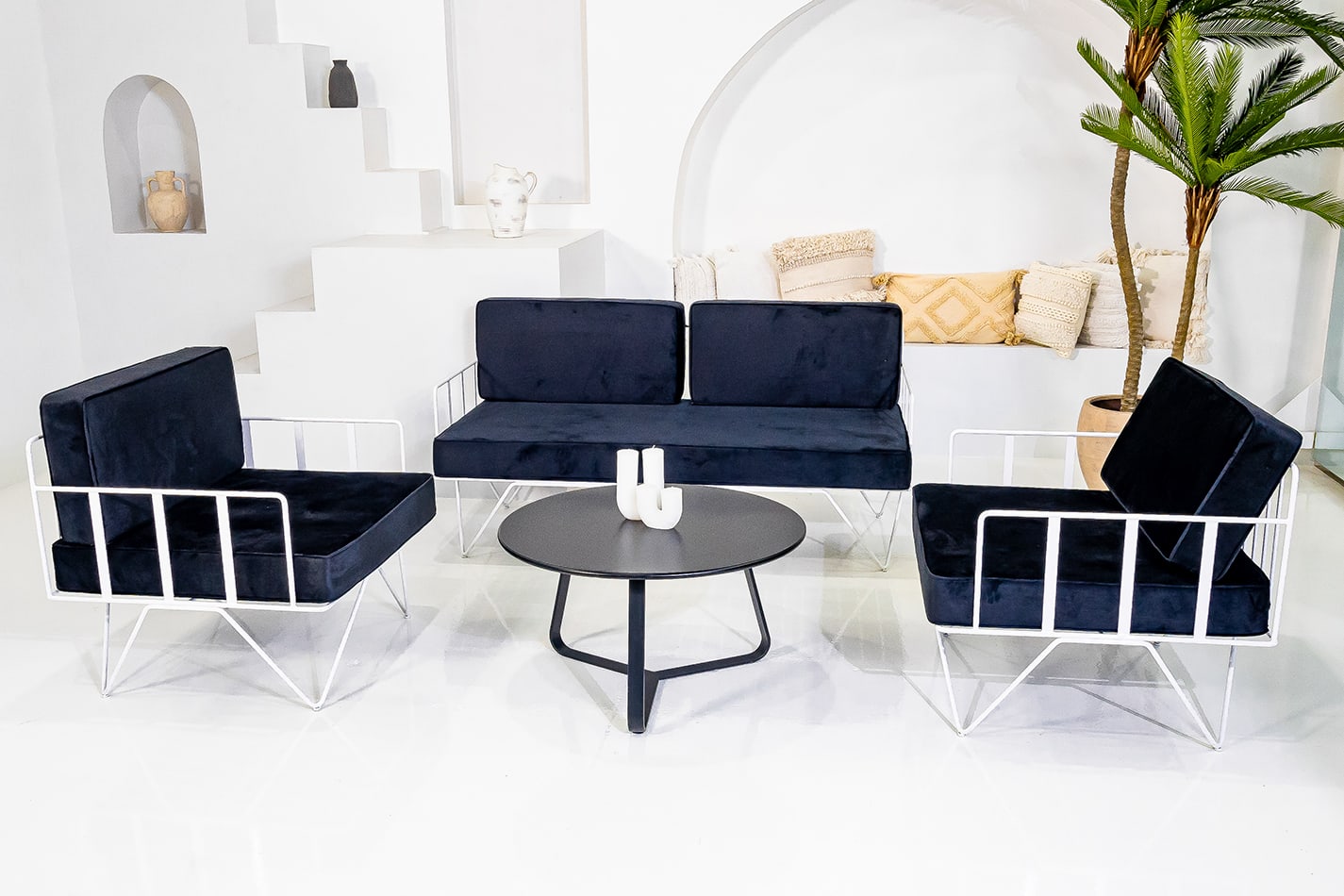 Black round coffee table in the middle of the lounge setting