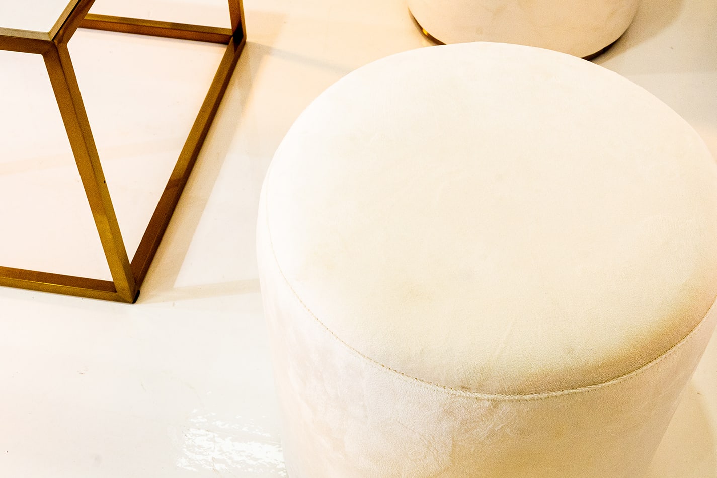 Close-up of a white velvet ottoman stool