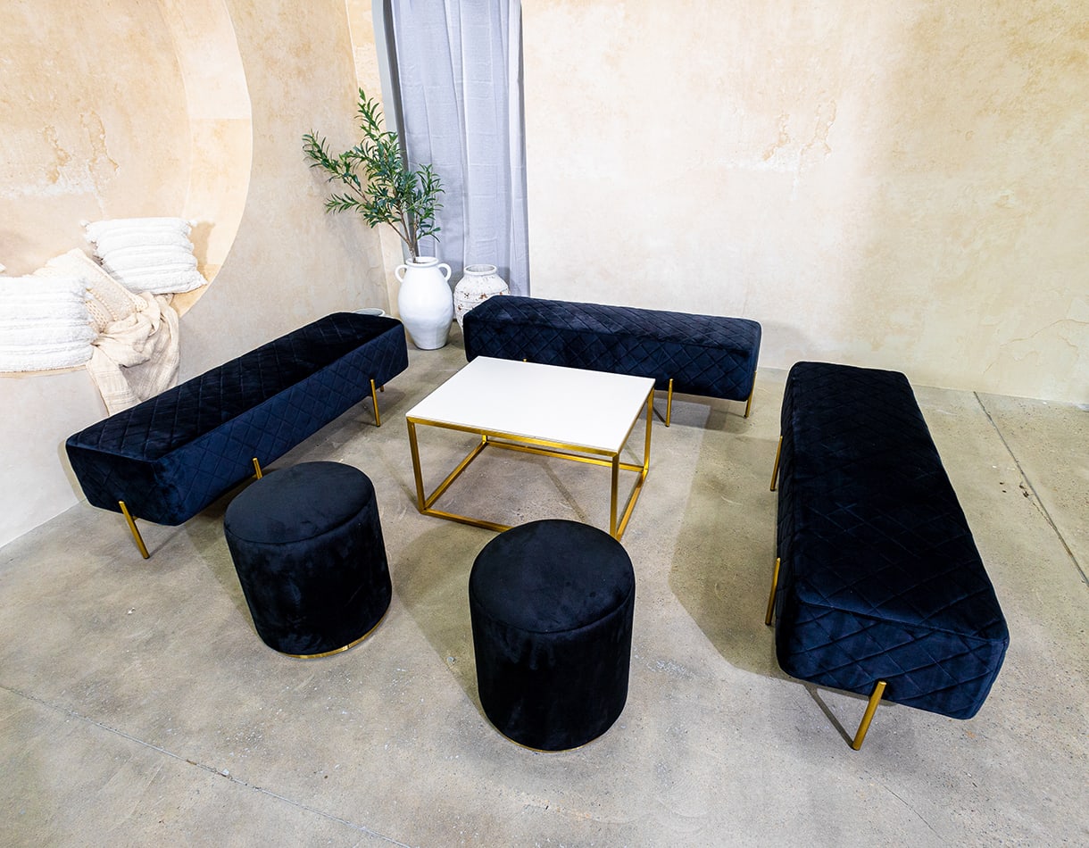 Black velvet ottoman stools next to an Ottoman lounge