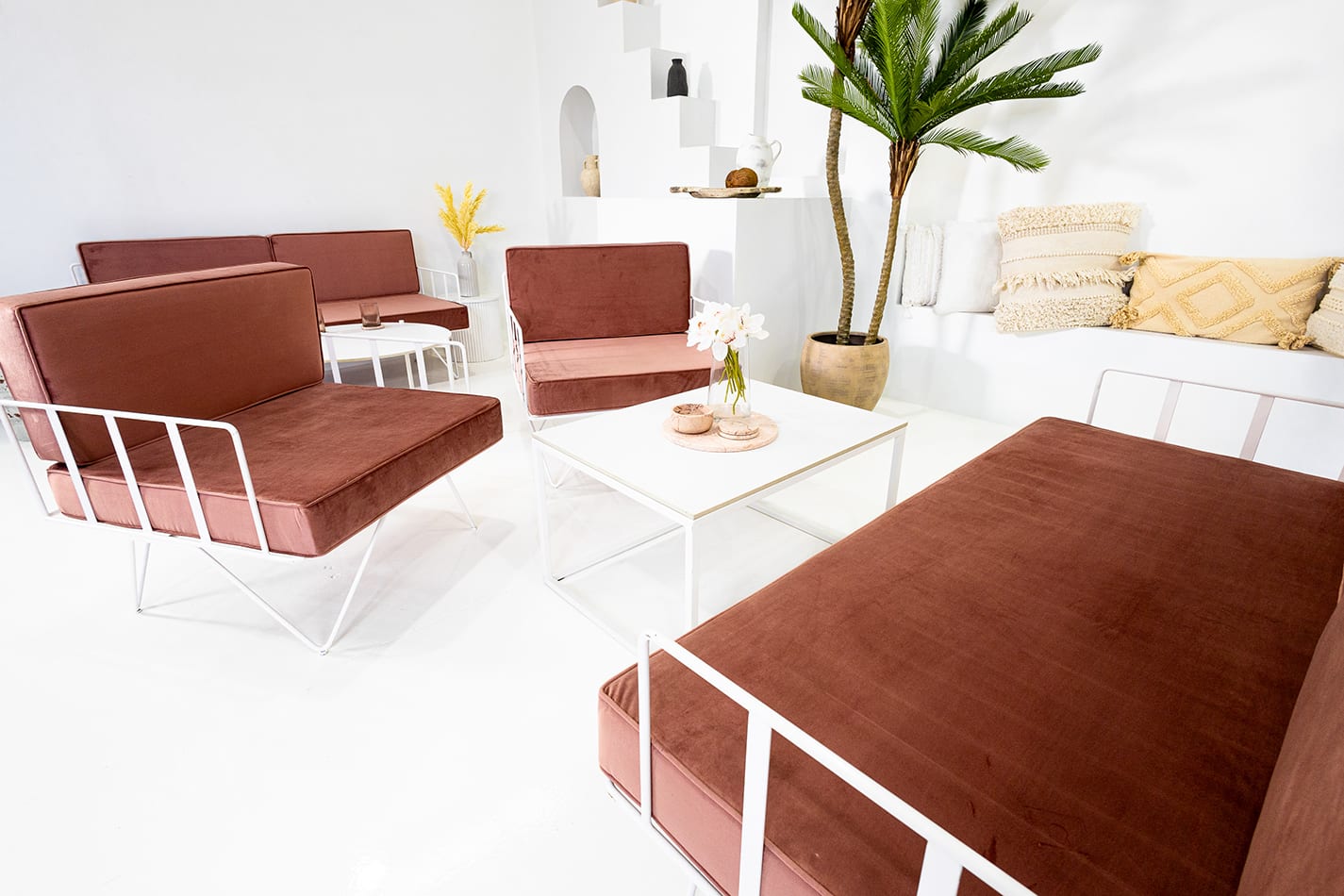 Pink velvet cushions on a white wire lounge chair