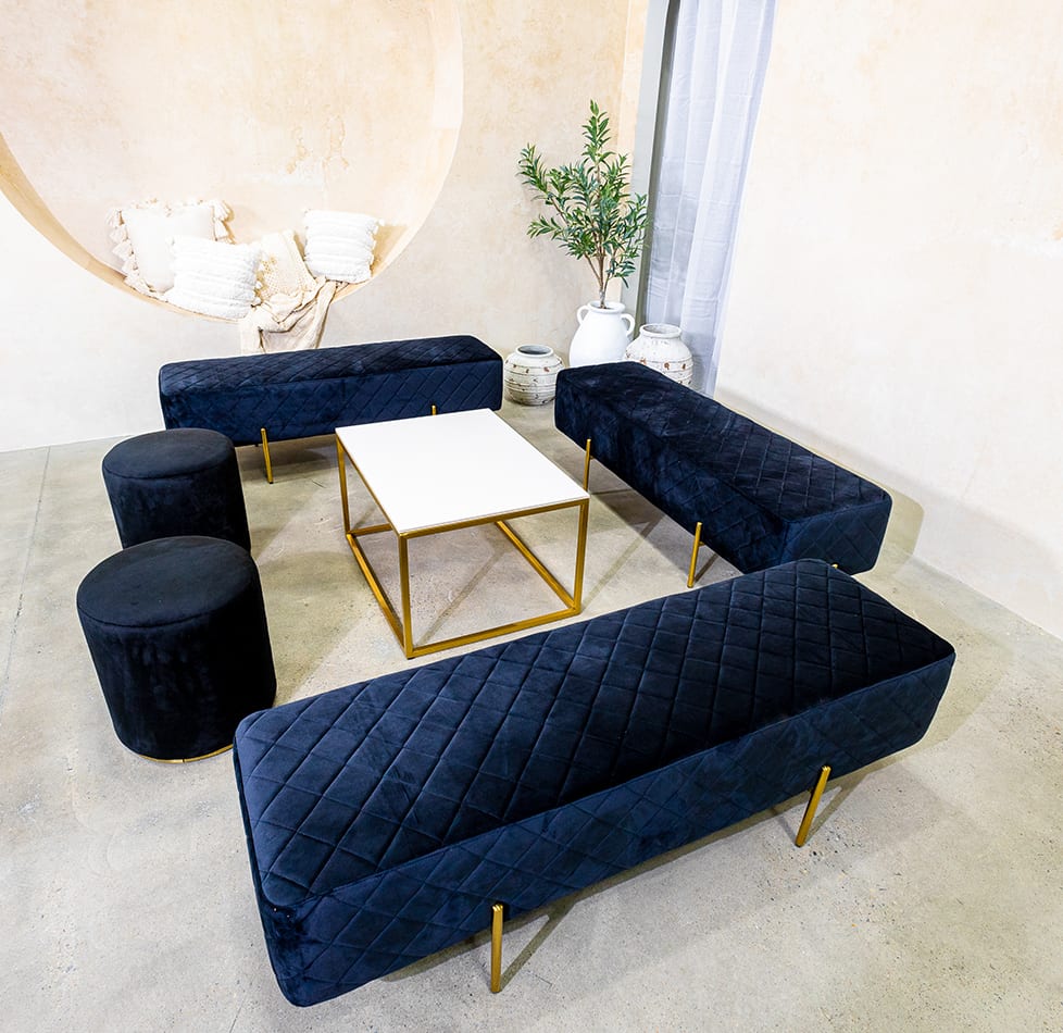 Black velvet ottoman benches around a coffee table