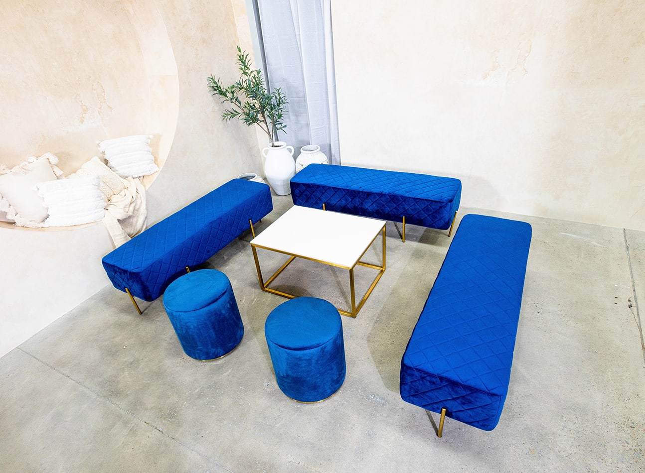 A lounge setting with navy blue ottoman benches