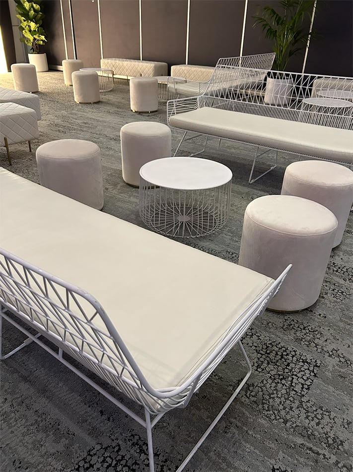 White Ottoman stools around a lounge setting