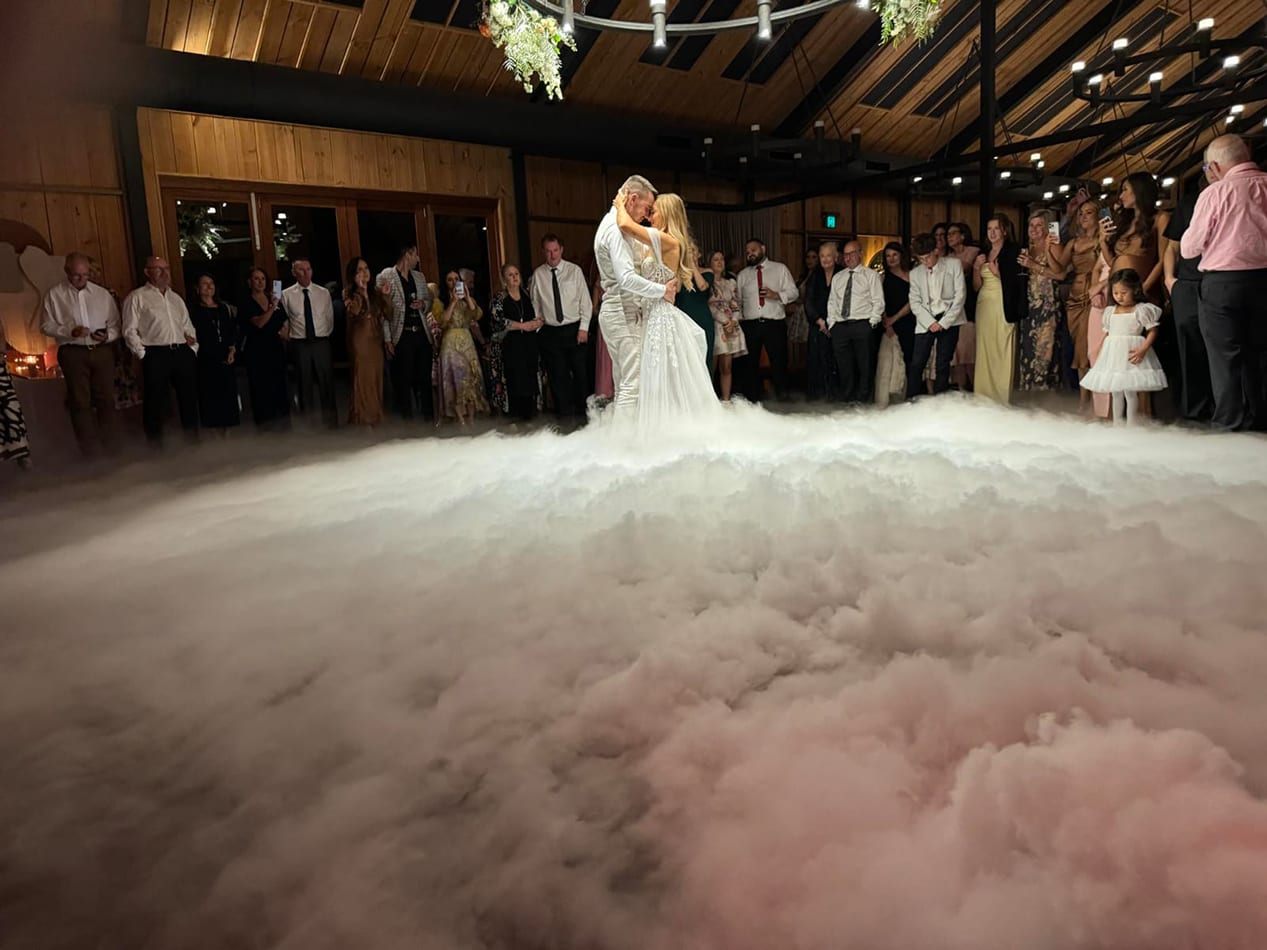 A dance floor covered in dry ice at a wedding