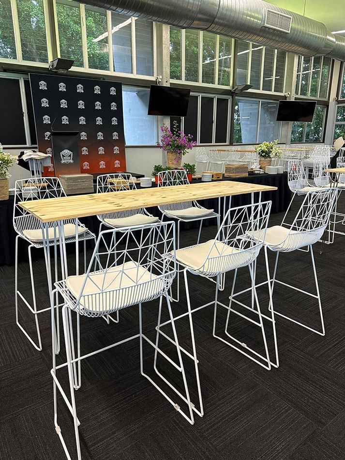 A white hairpin high bar table with timber top hired for a function