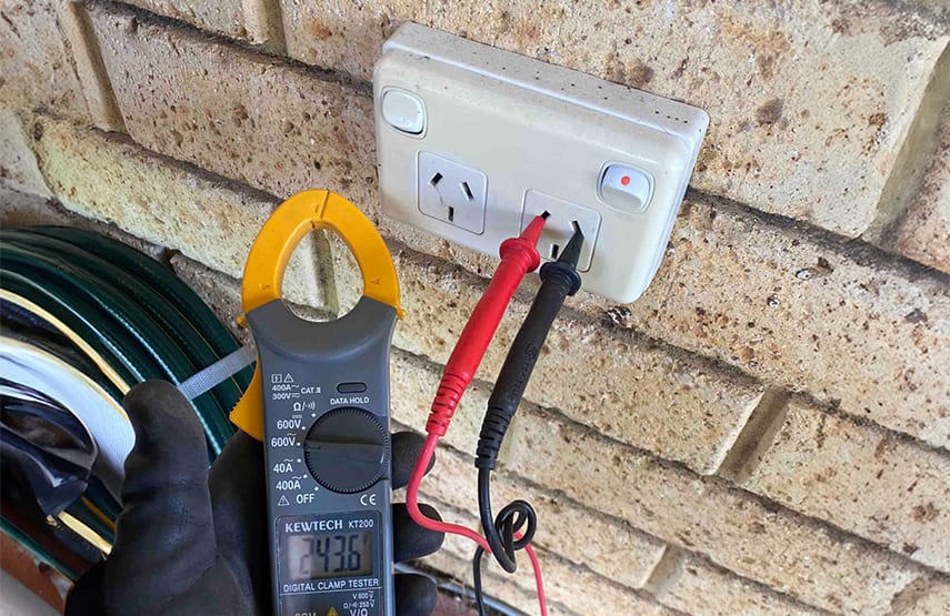 An electrician testing a power point in Sydney