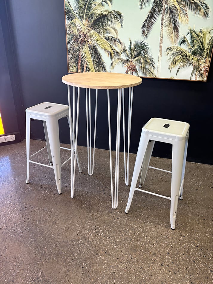 Our white round cocktail table under a painting with tolix stools