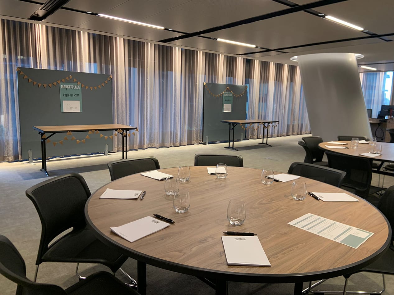 A large round office table with two partitions in the background