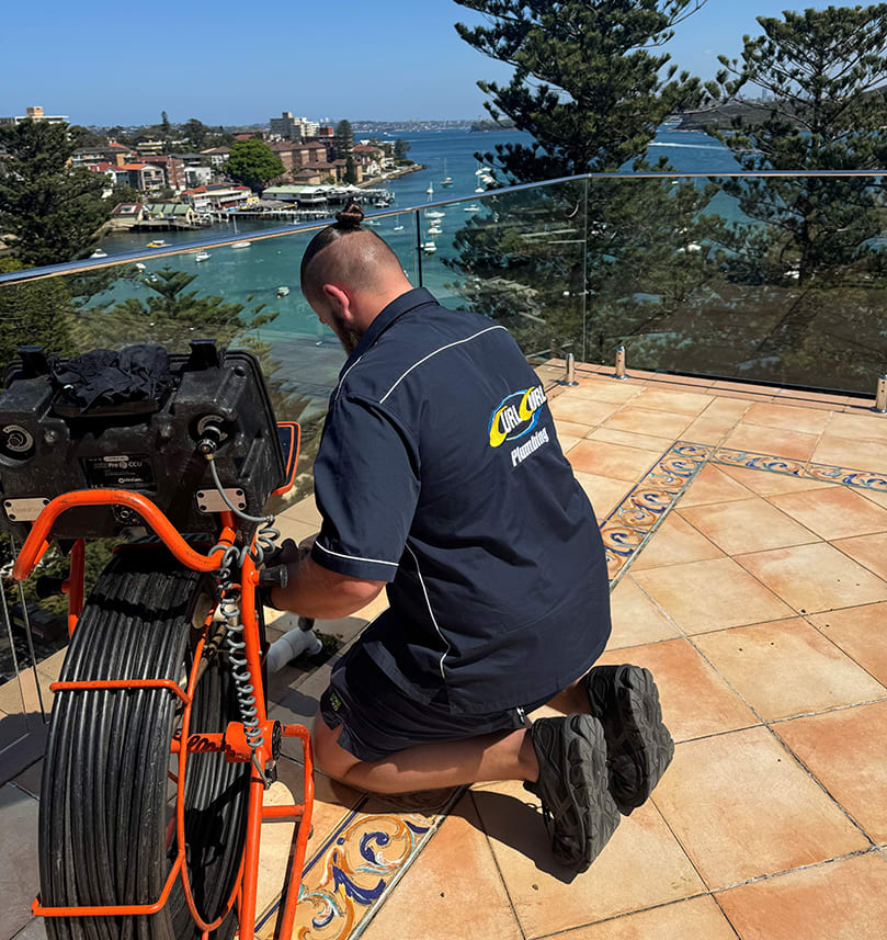 A plumber fixing a broken pipe on a rooftop