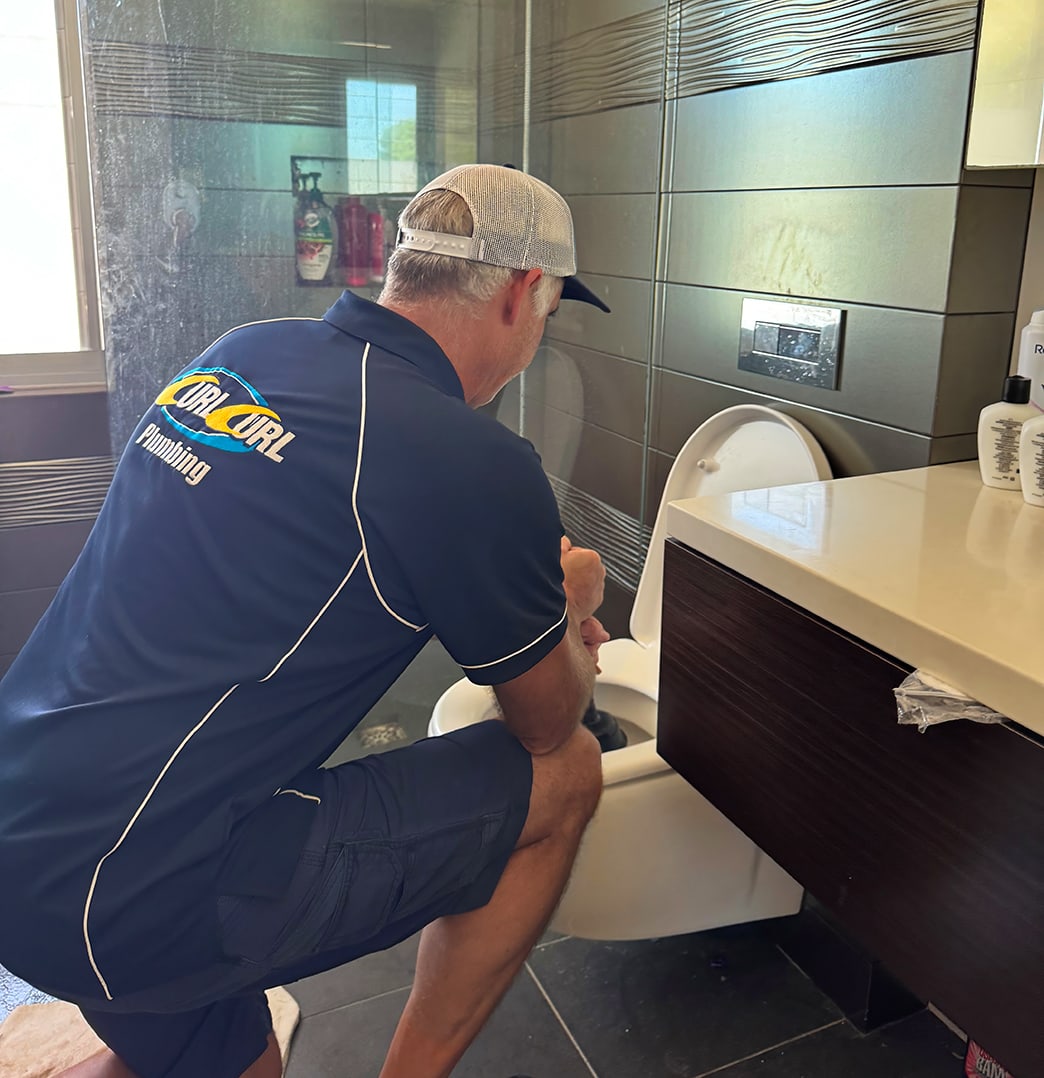 A plumber unblocking a stormwater drain in Sydney
