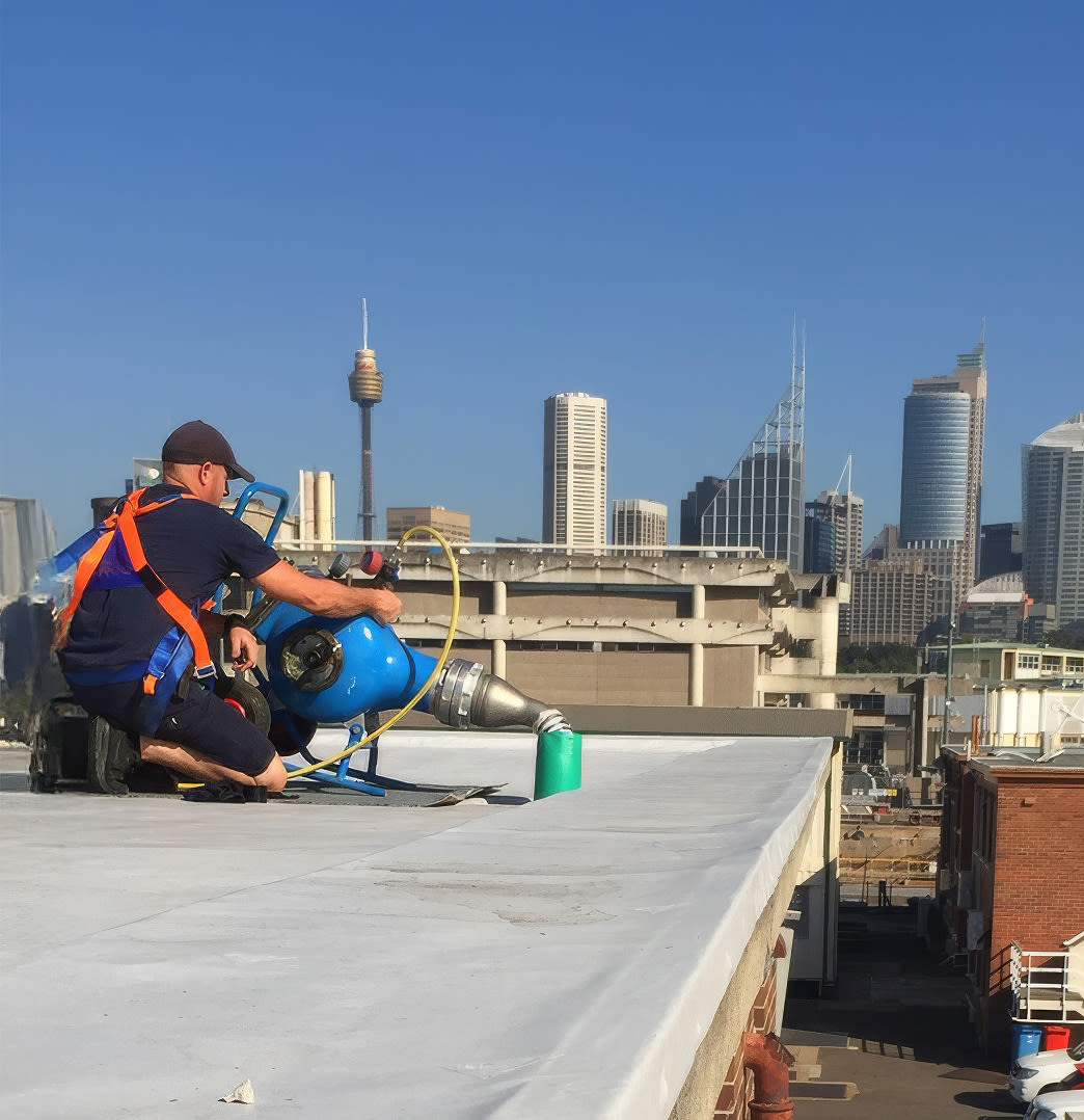 A Sydney plumber working on the roof top of a commercial building