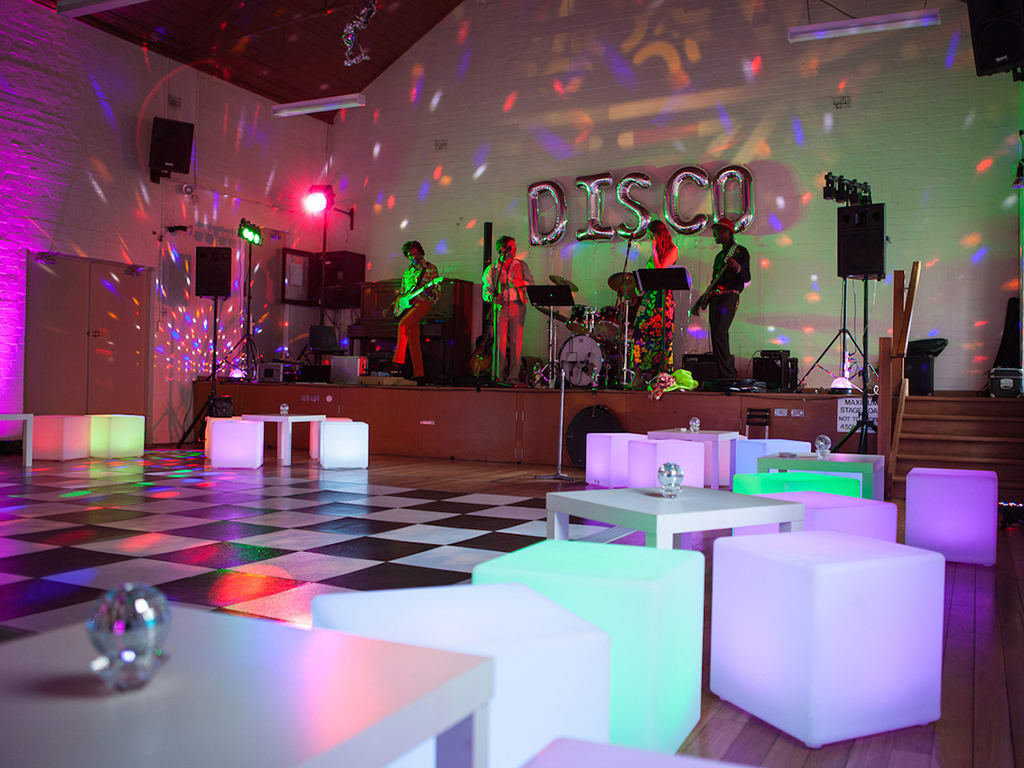 A disco set up with glow furniture and lighting