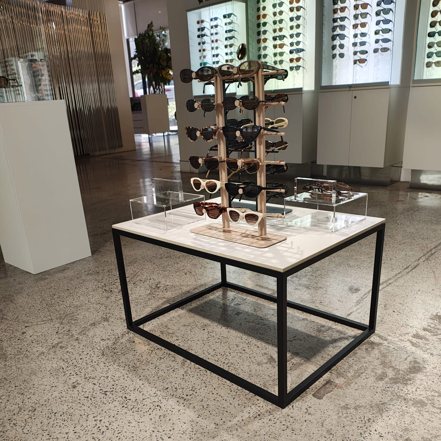 Black rectangular coffee table with a white top and sunglasses on top of it