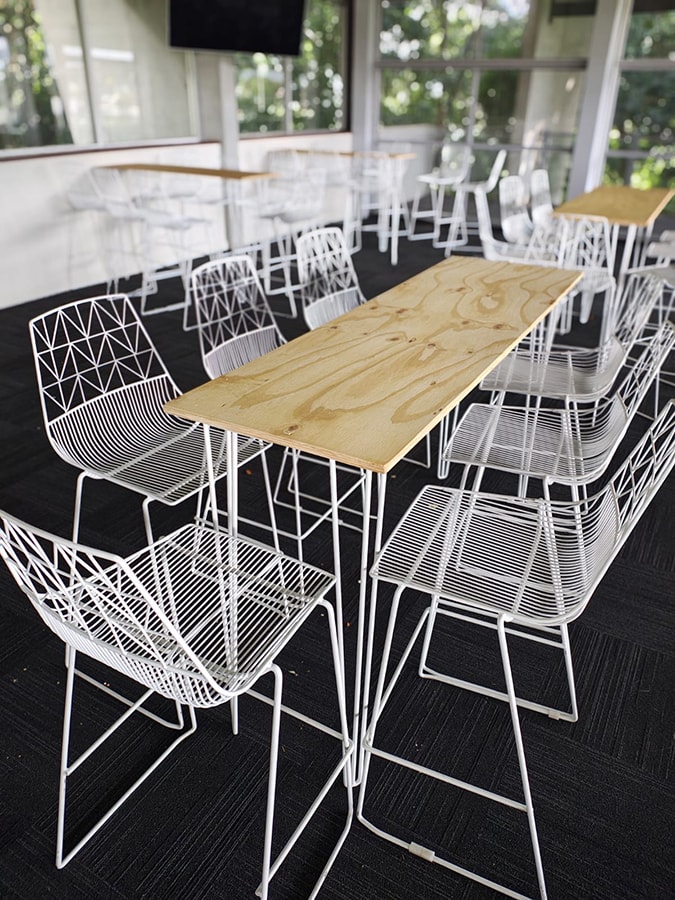 A few of our white wire timber top tables surrounded by wire tools at an event