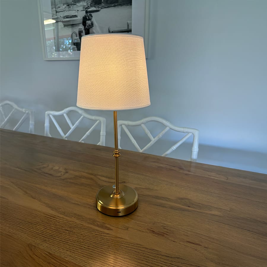 A white shade table lamp on a timber table