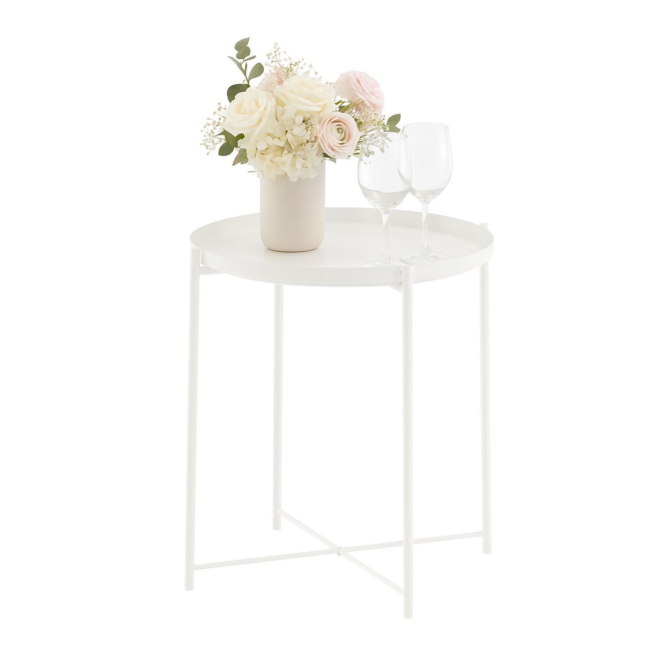 White round metal side table styled with a soft floral arrangement and glassware, photographed against a clean white background for product presentation.