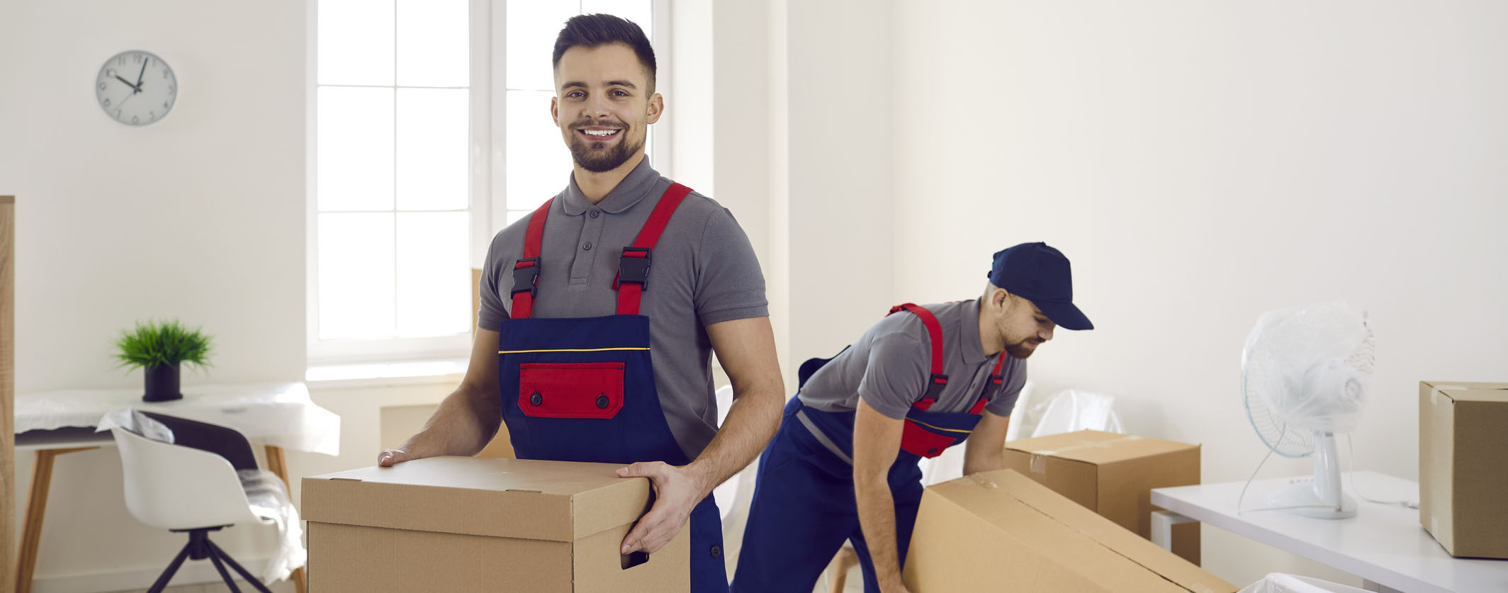 Two professional movers packing boxes