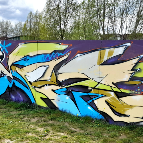 Abstracte graffiti met letters en kleurvlakken op de keerwand in Zwolle – vrij werk op legale graffiti-locatie.