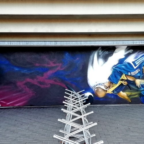 Sportieve graffiti-muurschildering op muur bij Skills Garden Veendam – project door Optyz met dynamisch sportthema.