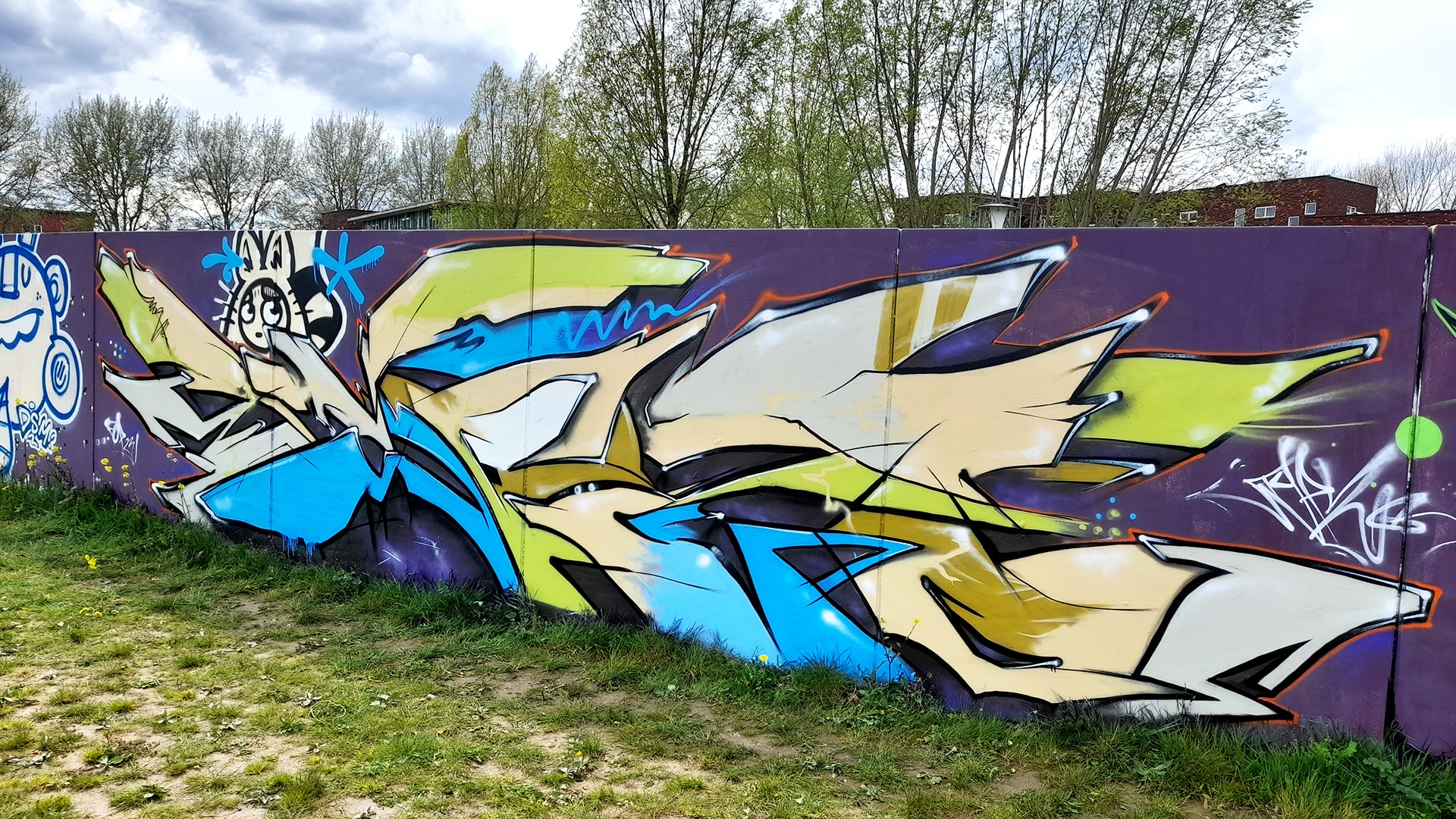 Abstracte graffiti met letters en kleurvlakken op de keerwand in Zwolle – vrij werk op legale graffiti-locatie.