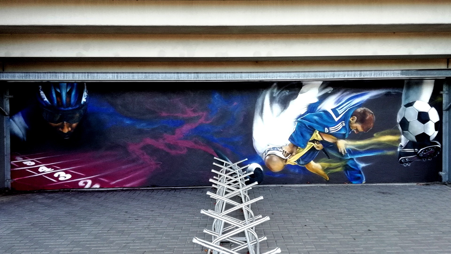 Sportieve graffiti-muurschildering op muur bij Skills Garden Veendam – project door Optyz met dynamisch sportthema.