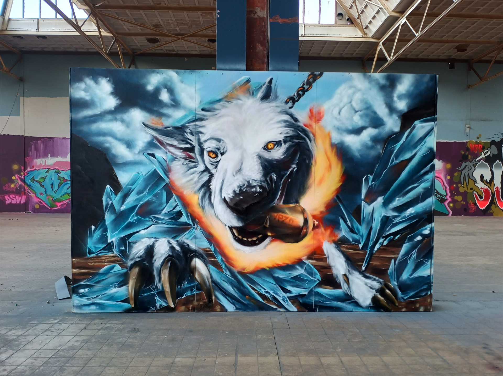 Graffiti muurschildering van Fenrir, geïnspireerd op een witte herder, met vuur, kettingen en een muur van ijs waarin letters verborgen zijn. Gemaakt tijdens de Artlane 203 graffiti jam in Roermond.